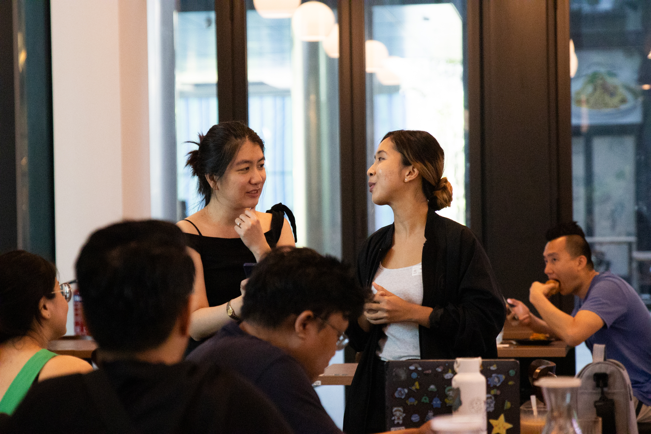 Two attendees in conversation at a DesignSG meet-up, discussing the case study.